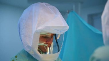 Koruyucu kıyafetli genç beyaz bir doktor. Operasyon ekibinde çalışan bir cerrahın portresi.