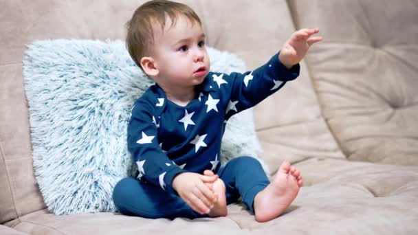 Cute Baby Blue Suit Sits Comfortable Sofa Lovely Toddler Stretches — Stock Video