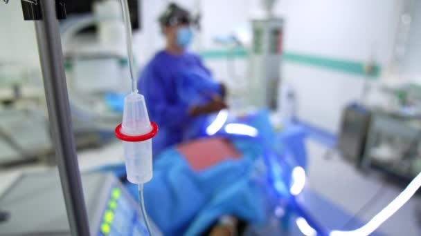 Ameliyathanede Bir Damlatıcıyla Duruyor Görüntü Perdesindeki Ameliyatta Çalışan Bir Cerrah — Stok video