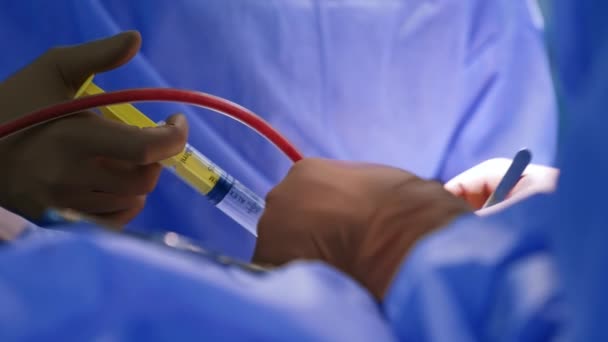 신경외과의사의 도구와 혈액이 튜브에 흐릅니다 의사는 약물로 주사기를 사용하고 있습니다 — 비디오