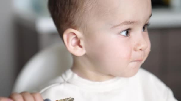 食事中に美しい白人の赤ちゃんの顔 口の周りに食べ物を持っている素敵な少年 ポートレートを閉じる — ストック動画