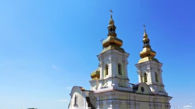 Güzel Hıristiyan Ortodoks katedralinin altın kupaları. Tarlakuşları hızla uçuyor. Mavi gökyüzü arkaplanı. Düşük açı görünümü.