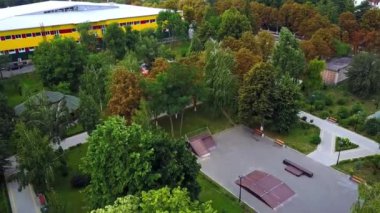 Rüzgar şehir parkında sert esiyor ve ağaçları sallıyor. Şehir bahçesinde büyük bir çeşme. Hava görünümü.