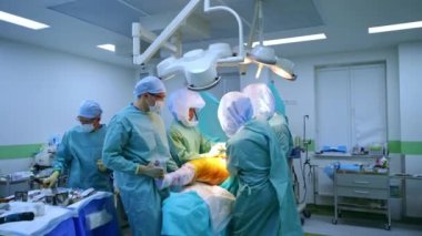 Cerrahi ekip bir bacağa travma ameliyatı yapıyor. Ameliyathaneden ayrılıp pencereden ameliyata bakmak..