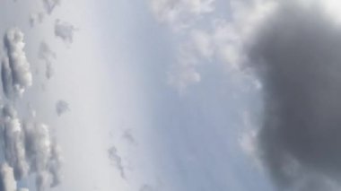 Gri kümülüs bulutları ufukta uçuşuyor. Düşük açıdan dramatik yağmurlu bir gökyüzü. Zaman ayarlı. Dikey ekran.