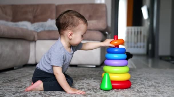 Schöne Kind Demontiert Bunte Spielzeug Pyramide Sitzt Auf Dem Boden — Stockvideo