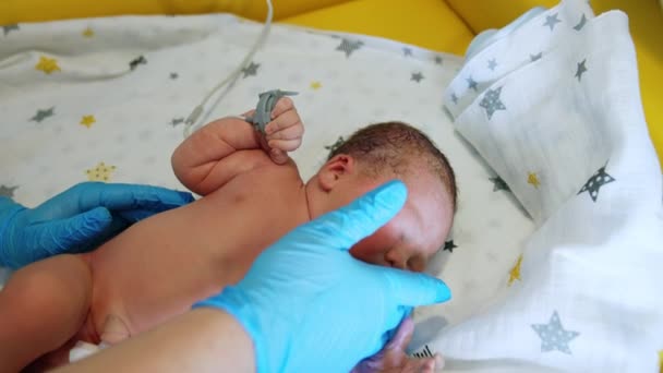 生まれたばかりの白人赤ちゃんの世話をする看護師 明るい光からウィンクするかわいい子供 クローズアップ — ストック動画