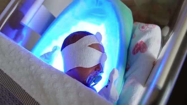Nyfött Barn Med Napphållare Ligger Spjälsängen Ultraviolett Lampa Ljusbehandling Förlossningssjukhuset — Stockvideo