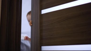 Meraklı küçük çocuk kapıyı dikkatlice açar. Çocuk sevinçle odaya koştu..