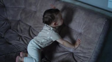 Neşeli oğlan ayağa kalkar ve odanın ışığını açar. Çocuk mutlu bir şekilde işaret ediyor.