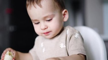 Tatlı çocuk öğle yemeğinde muz yiyor. Yemek yerken bir çocuğun portresi. Kapat..