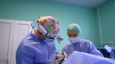Modern kliniklerde tiroidektomi. Farlı bir cerrah elektrikli cihaz kullanır. Prosedürü izlemede hemşireye yardımcı oluyorum..