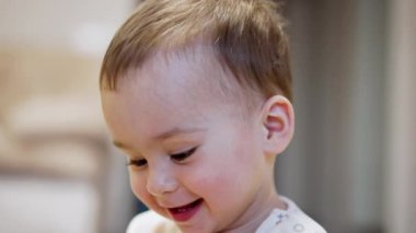 Mutlu bir yıllık bebek portresi. Gülümseyen beyaz çocuk yaklaş. Bulanık arkaplan.