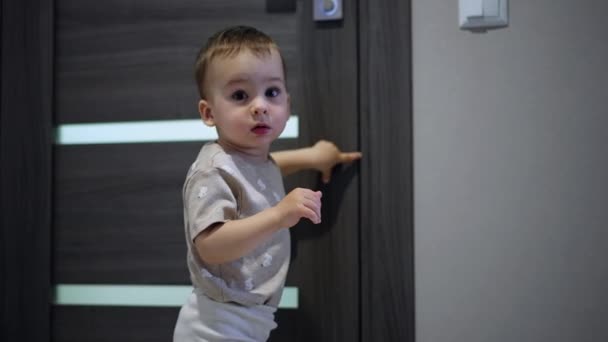 Menino Bonito Criança Está Nas Portas Tocando Com Dedo Miúdo — Vídeo de Stock