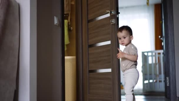 Słodki Chłopczyk Podchodzi Otwartych Drzwi Dzieciak Zatrzymuje Się Chwilę Zamyka — Wideo stockowe