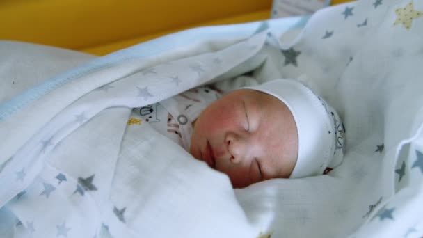 小さな生まれたばかりの赤ん坊を帽子と毛布で眠らせました 子供は睡眠中に口を開きます クローズアップ — ストック動画