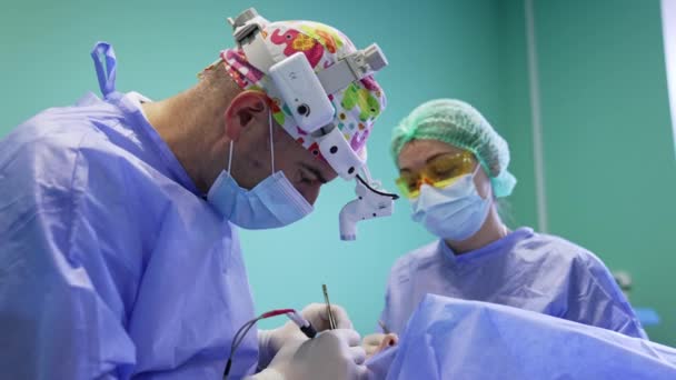 Blepharoplastyka Wykonywana Przez Chirurga Noszącego Reflektory Lekarz Ostrożnie Wykorzystuje Urządzenie — Wideo stockowe