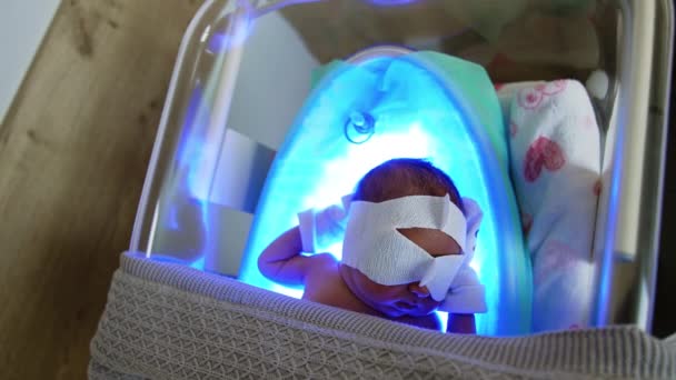 Ребенок Лежит Кроватке Одеялом Ультрафиолетовой Лампе Новорожденный Проходит Желтушное Лечение — стоковое видео