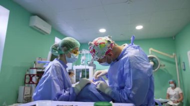 Doktor göz kapakları üzerinde hassas prosedürler uygular. Profesyonelce işlerinde metal aletler kullanmak zaman alır. Kadın doktor asistanı..