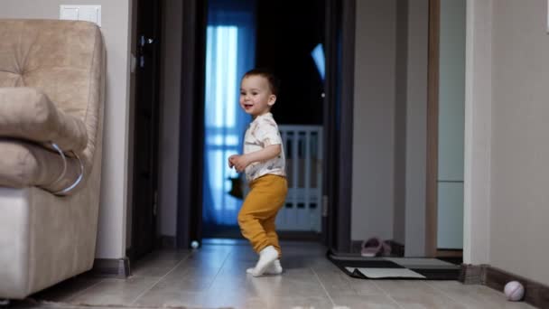 快乐的蹒跚学步的男孩在房子里快乐地跑来跑去 笑宝宝在家里玩的开心 — 图库视频影像