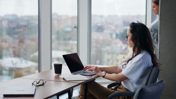 Женщина Работает Ноутбуке Сидя Столом Беременная Коллега Подходит Окну Телефоном — стоковое видео