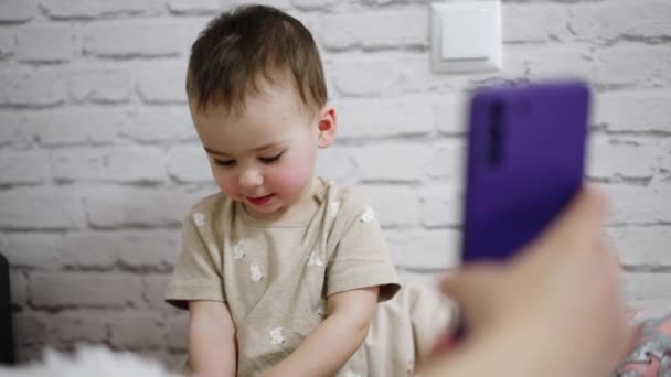 Рука Взрослого Показывает Телефон Маленькому Ребенку Ребенок Смотрит Гаджет Интересом — стоковое видео