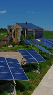 Doğada güneş panelleri olan bir bina. Yol boyunca mavi güneşli bataryalar. Fotovoltaik hücreler yaz aylarında güneş ışığında ekolojik enerji üretirler. Dikey video