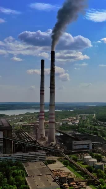自然中的工业区 工厂在蓝天的衬托下铺设管子 工业管道冒出黑烟 以自然为背景的制造业全景观 垂直录像 — 图库视频影像