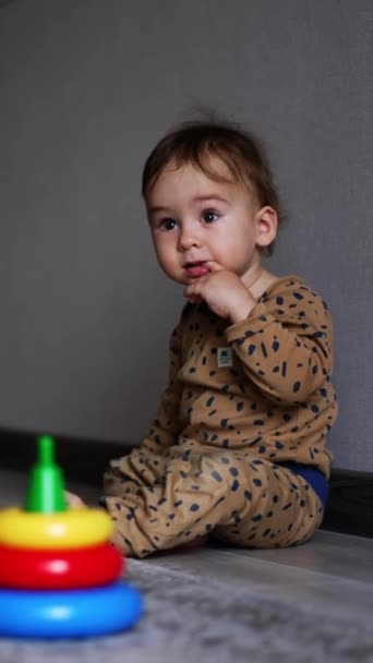 Criança Encantadora Sentada Parede Quarto Espaçoso Segurando Dedo Boca Menino — Vídeo de Stock