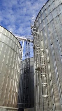 Alüminyum tahıl asansörleri. Hasat için tarım malzemeleri. Modern depo. Güneşli bir günde tahıl ambarı. Yakın plan. Dikey video