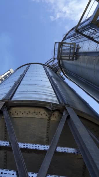 金属貯蔵タンク 青空に対する大きな穀物エレベーター 現代の倉庫 クローズアップ 下からの眺めです バーティカルビデオ — ストック動画
