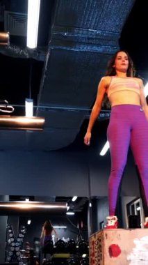 Formda atletik kadın spor salonunda boks yapıyor. Yoğun egzersiz günlük çapraz fitness eğitim programının bir parçasıdır. Dikey video