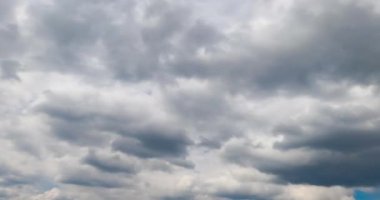 Atmosferde hareket eden gri bulutlar. Kümülüs bulutları yağmurdan önce toplanıyor. Düşük açı. Zaman Uygulaması.