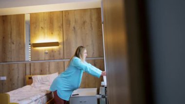 Sarışın kadın kasılmalardan kurtulmak için pencere eşiğine yaslanıyor. Kadın doğum için doğum bölümüne hazırlanıyor..