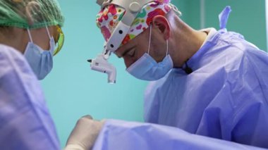 Renkli şapka takan ve farlarını yakan bir posta cerrahının yan görüntüsü. İş yerinde bir tıp uzmanının portresi. Kadın doktor asistanı..