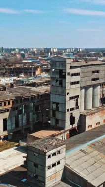 Terk edilmiş bina. Eski bir fabrika harabesinin ve kırık camların havadan görünüşü. Dikey video