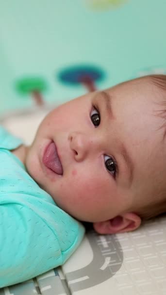 Hübsches Baby Liegt Auf Dem Rücken Blauer Kleidung Und Hält — Stockvideo