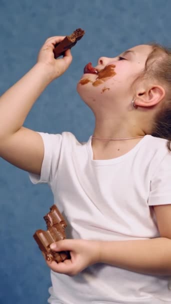 Χαριτωμένο Κορίτσι Γλείφει Σοκολάτες Μέσα Ευτυχισμένο Παιδί Τρώει Νόστιμα Γλυκά — Αρχείο Βίντεο