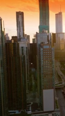 Gün batımında inanılmaz büyükşehir manzarası. Turuncu gökyüzünün arka planında güzel Chicago gökdelenleri. Dikey video