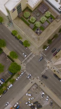 Chicago şehir merkezindeki kavşaktan geçen arabalar. Şehir çatıları ve gündüz vakti otoparkların manzarası. Dikey video