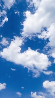 İnanılmaz hafif pamuk bulutları uçar ve gökyüzünde kaybolur. Bulutlardan mavi ufuk temizliği. Düşük açı. Dikey video