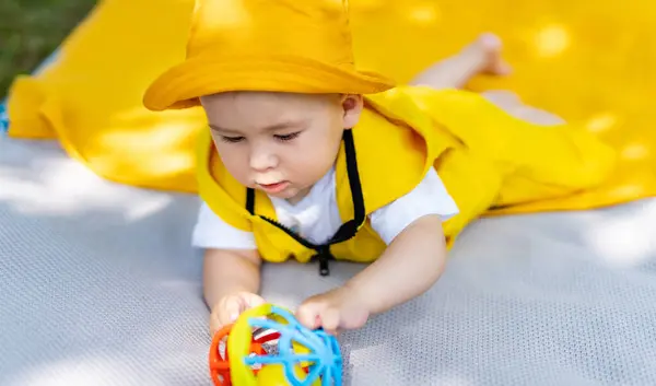 Dziecko Leży Kocu Trzyma Zabawkę Dziecko Sobie Żółty Kapelusz Żółty Obrazek Stockowy