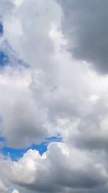 Güneşli bir yaz gününde yumuşak pamuk bulutları üzerinde uçuyorlar. İlahi kümülüs beyaz bulutlar hareket zamanı geldi. Dikey video