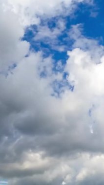 İnanılmaz kümülüs bulutları arasında ilerliyorum. Yaz günü parlak güneş ışığında beyaz bulutlar. Zaman ayarlı. Dikey video