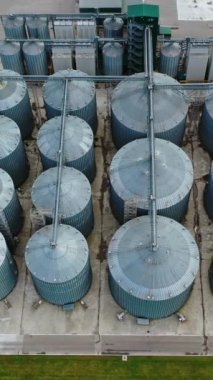 Büyük çelik asansörler. Tarladaki tahıl ambarları. Tarım fabrikasındaki gümüş silolar. Yukarıdan bak. Dikey video