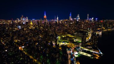 Alacakaranlıktaki New York manzarası harika. Neon ışıklı muhteşem gökdelenlere yaklaşıyoruz. Üst görünüm.