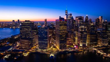 Beautiful city view with multiple lights on. New York panorama from drone photo above the East River. Aerial view. clipart