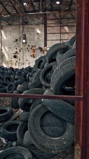 一堆汽车轮胎在一个废弃的工厂里 看看里面的旧工厂 垂直录像 — 图库视频影像