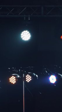 Renkli spot ışıklarıyla ya da birkaç parlak projektörlü karanlık sahne. Akşamları ışık efektleri olan farklı projektörler. Dikey video