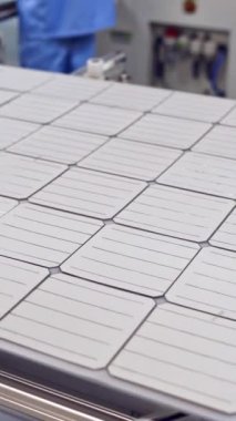 Güneş paneli, robotik fabrikadaki taşıyıcı bantta hareket ediyor. Ekolojik güneş pilleri üreten modern bir bitki. Otomatik fabrika içeride. Dikey video